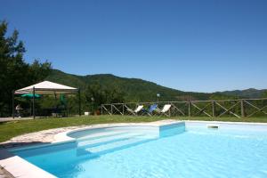 a swimming pool in a yard with a table and chairs at Borgo Antico in Poggioni