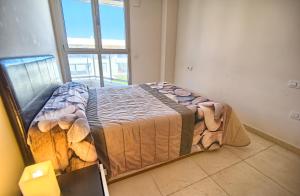 a large bed in a room with a window at Valencia Beach Apartments in Valencia