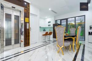 a kitchen with a table and chairs in a room at Luxury Homestay Vinhomes Dragonbay Hạ Long in Ha Long