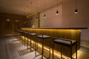 a row of stools in a bar with lights at Jiayuguan Tuzhu Hotel in Jiayuguan