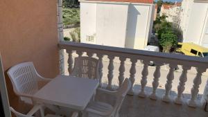 a white table and two chairs on a balcony at Ratko Peris in Novalja