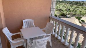 a white table and chairs on a balcony at Ratko Peris in Novalja