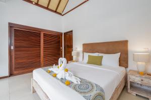 a bedroom with a large bed with a flower on it at Villa Nolan - Modern 3BR Private Villa with Pool in Padonan, Canggu in Kerobokan