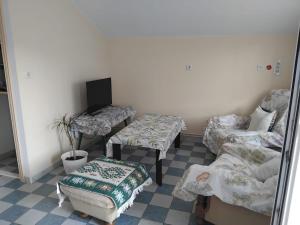 a room with three beds and a tv and a chair at Jenny`s House in Supetar
