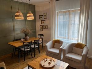 a living room with a table and chairs at Zöld Cica Vendégház in Hévíz +20 photos