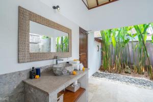 a bathroom with a stone sink and a mirror at Villa Nolan - Modern 3BR Private Villa with Pool in Padonan, Canggu in Kerobokan