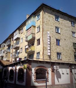 Un gran edificio de ladrillo con un cartel en él. en Лободы 34 красиво и уютно, en Karagandá