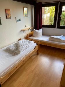 a bedroom with two beds and a window at Ferienhäuser Fedderwardersiel Am Yachthafen 93 in Fedderwarderdeich