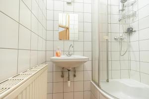 biała łazienka z umywalką i prysznicem w obiekcie Simple Apartment near Wiener Stadthalle w Wiedniu