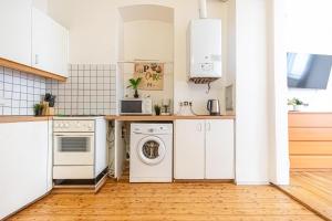 kuchnia z białymi urządzeniami i drewnianą podłogą w obiekcie Simple Apartment near Wiener Stadthalle w Wiedniu +28 zdjęć