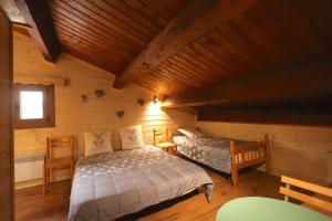 een slaapkamer met twee bedden in een blokhut bij Chez Maguy Chambres d'hôtes in Les Angles +11 foto's