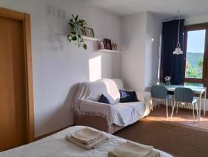 a bedroom with a bed and a table and a couch at Eguzkilore Larunbe apartamento in Larumbe