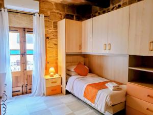 a small bedroom with a bed and a window at Mdina Gate Retreat - A charming house of character in Rabat