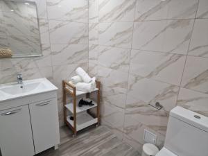 a bathroom with a white sink and a marble wall at Apartamente Topaz Sea View Olimp in Olimp +25 photos