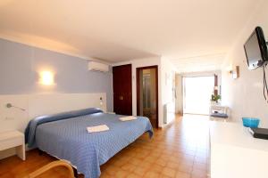 Un dormitorio con una cama azul y un televisor. en Cala Figuera Studio 6b, en Cala Figuera