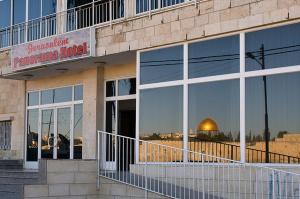 a building with a reflection of the dome of the rock in the windows at Jerusalem Panorama Hotel in Jerusalem