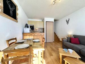 una cucina e un soggiorno con un tavolo e un divano di Résidence L'alpage - APPARTEMENT PIED DES PISTES MAE-4591 a Vars