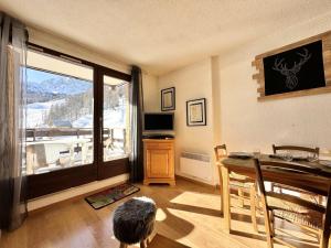un soggiorno con un tavolo e una grande finestra di Résidence L'alpage - APPARTEMENT PIED DES PISTES MAE-4591 a Vars