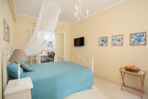 - une chambre avec un lit bleu et une télévision dans l'établissement Orfeas House Corfu, à Corfou