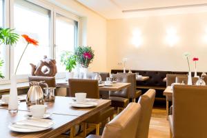 a restaurant with wooden tables and chairs and windows at Hotel Nürnberger Trichter in Nuremberg +20 photos