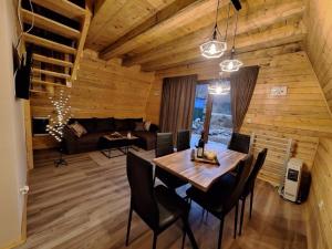 una sala da pranzo con tavolo e sedie di Brvnare Todorovic a Crni Vrh Altre 15 foto