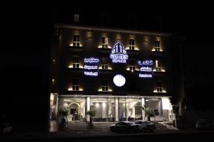 a building with neon signs on it at night at Golden square قولدن سكوير in Khamis Mushayt