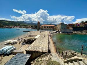 a beach with a pier and the water at Lumières à Collioure in Collioure