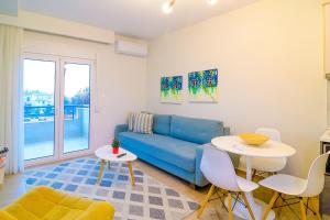 a living room with a blue couch and a table at Eternal Suites Edessa in Edessa
