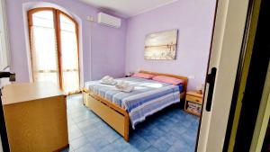 Un dormitorio con una cama en una habitación con paredes moradas. en Le Pleiadi - Casa Casoni, en Marcelli