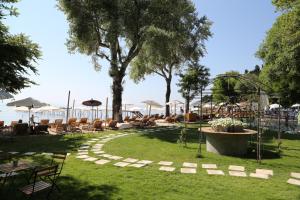 un parc avec des tables et des chaises et un arbre dans l'établissement Orfeas House Corfu, à Corfou