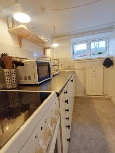 a kitchen with a microwave on a counter at Central Apartment In Aalborg Close To Hospital in Aalborg +8 photos