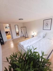 a bedroom with a white bed and a potted plant at Central apartment in Aalborg close to Hospital in Aalborg