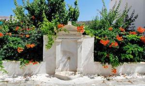 a monument in front of some flowers at Castel Abaso Boutique Apartments by Explore Andros in Andros