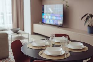 a dining room table with plates and glasses on it at Premium Loft ǀ 2-Bedrooms, AC, 85 sqm, Free Parking in Bratislava