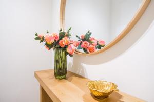 a vase of flowers on a table in front of a mirror at GuestReady - Charming home in Câmara de Lobos in Câmara de Lobos