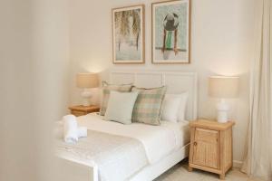 a bedroom with a white bed with two two lamps at Whitehaven - 100m to Beach, Private Pool in Yaroomba