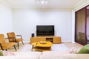 a living room with a couch and a tv at GuestReady - Charming home in Câmara de Lobos in Câmara de Lobos