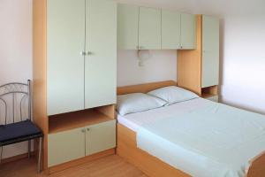 a small bedroom with a bed and a cabinet at Apartments Vink in Vir