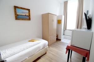 ケルンにあるDiamonds Loft Hotel Kölnのベッドルーム1室(ベッド1台、キャビネット、窓付)