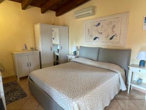 a bedroom with a bed with a white bedspread and two tables at Vento di Grecale in Favignana +14 photos