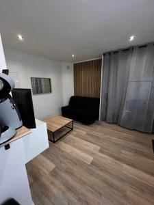 a living room with a couch and a television at joli petit studio in Mantes-la-Jolie +2 photos