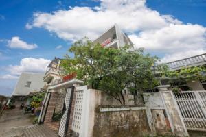 un bâtiment blanc avec un arbre devant lui dans l'établissement Trường Ân Homestay, à Hue 21 autres photos