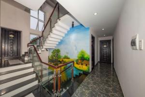 un couloir avec un escalier orné d'une peinture murale. dans l'établissement Trường Ân Homestay, à Hue
