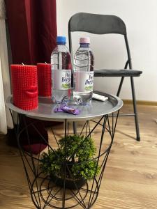 two bottles of water on a table with a chair at Magic Apartments 2 in Miercurea-Ciuc +5 photos