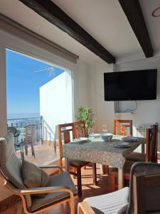a living room with a table and chairs and a large window at Apartamento Nievesol con 2 Parking y WiFi in Sierra Nevada