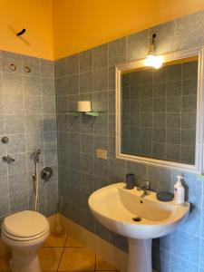 a bathroom with a sink and a toilet and a mirror at Vento di Grecale in Favignana