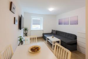 a living room with a couch and a table at Grom Ribno Apartments in Bled