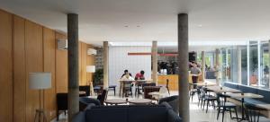Un restaurante con mesas y sillas y gente al fondo. en Bungalow Homes, en Bandung