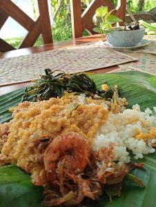 un plato de comida con camarones y arroz en una hoja de plátano en Villa Weligama Gedara, en Weligama