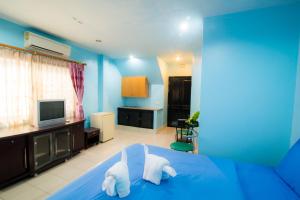 a blue room with a bed and a television at DE Apartment in Pattaya South